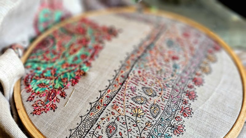 Broderie traditionnelle en cours sur tambour avec motifs geometriques anciens slaves