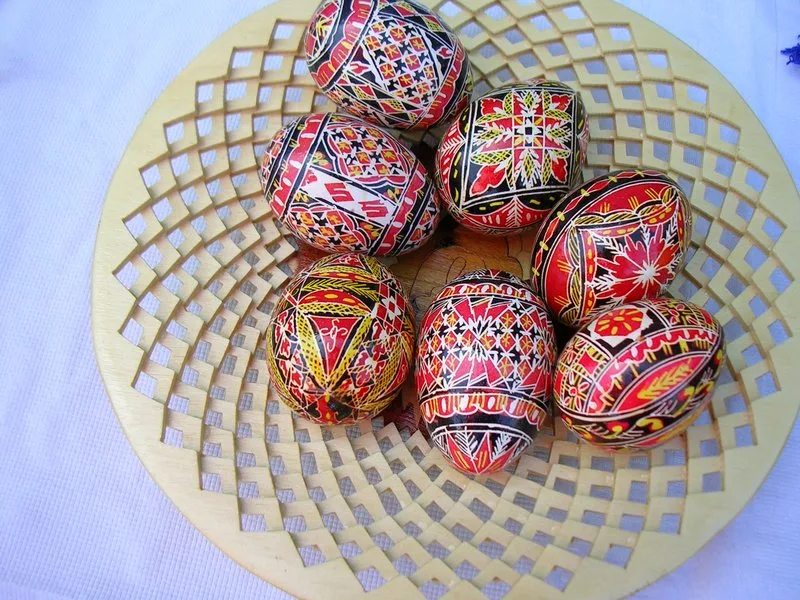 Panier de Pissankas ukrainiennes decorees de motifs geometriques traditionnels en rouge, noir et jaune